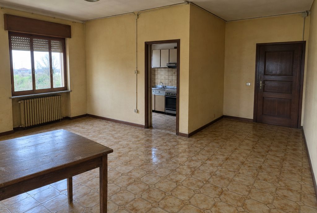 Soggiorno anni '80 con cucina chiusa da un muro, pavimento datato